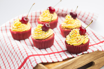 Cupcakes with whipped cream decorated with a cherry made without lactose