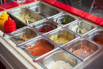 Refrigerated display case with metal containers containing fast food salads