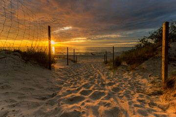 Eingang zu einem Sandstrand bei einem wunderschönen Sonnenuntergang