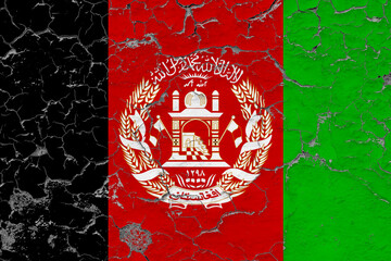 Afghanistan flag close up grungy, damaged and weathered on wall peeling off paint to see inside surface. Vintage concept.