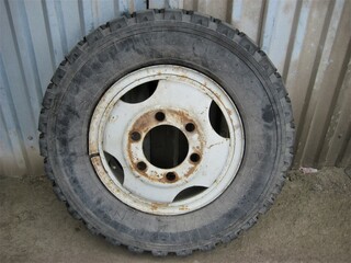 Fototapeta na wymiar an old abandoned big car wheel in an old dirty garage
