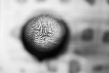 Close-up of a fingerprint in a police report through a magnifying glass. investigation of a crime....