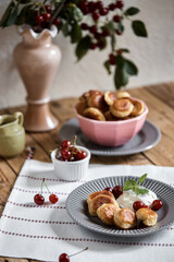 Obraz na płótnie Canvas Mini-pancakes, pancakes with cherries and sour cream. Homemade baking. tiny pancakes, ceral pancake