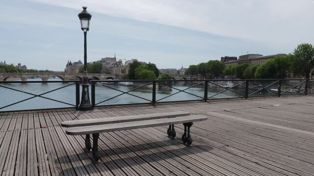 Pont des Arts bridge empty with nobody during corona virus crisis, wide panning shot during summer day in Paris France