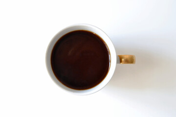 Espresso in a white cup with golden handle. Shot from above.