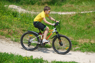 Fototapeta na wymiar A child riding a bicycle in the park. Healthy lifestyle