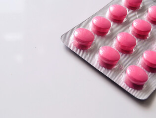 Pink painkiller pills in grey packaging.