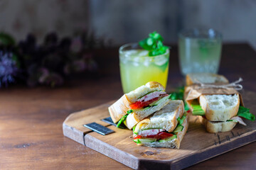 Naklejka na ściany i meble Ciabatta sandwich with turkey, lettuce, tomatoes, cheese on a wooden board.