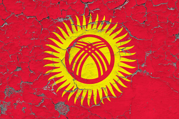 Kyrgyzstan flag close up grungy, damaged and weathered on wall peeling off paint to see inside...