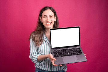 Fototapeta premium Look at the blank screen of this laptop says the girl holding it over pink background