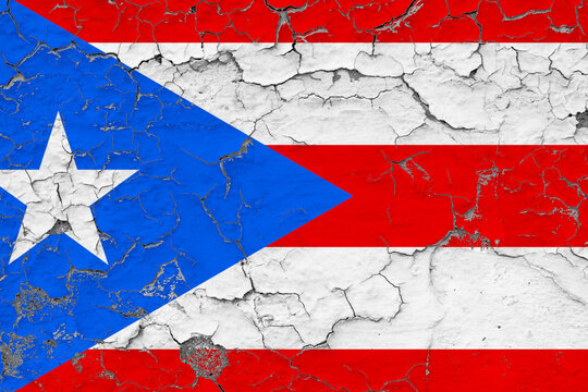 Puerto Rico flag close up grungy, damaged and weathered on wall peeling off paint to see inside surface. Vintage concept.