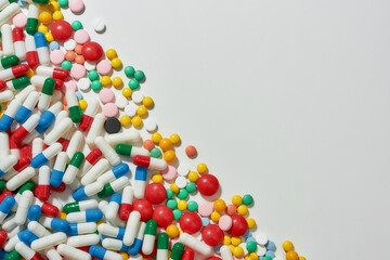 Different pills, capsules scattered diagonally over white background. Health care, vitamins and treatment concept