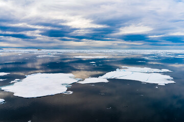 Cloudy sky and Ice pieces on the water in Arctic