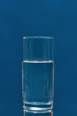 Glass of drinking water isolated on a blue background