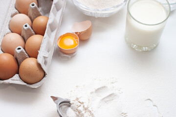 Baking ingredients: flour, eggs, sugar, butter, milk and spices on gray marble background