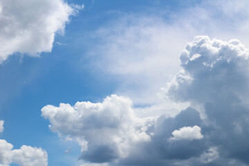 Naklejka na ściany i meble Beautiful cumulus clouds floating across the blue sky on a clear sunny day
