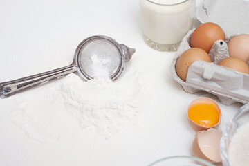 Baking ingredients: flour, eggs, sugar, butter, milk and spices on gray marble background
