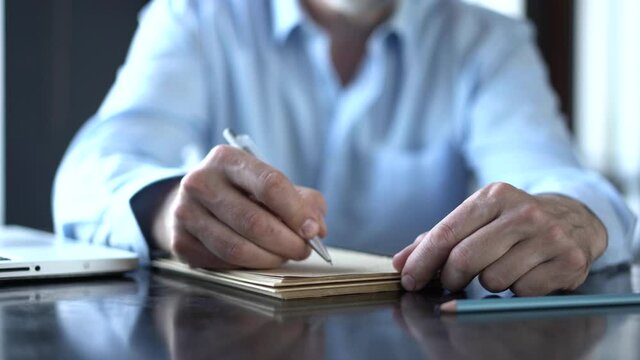 Man hand writing with pen at dairy. Closeup of business man hand write notes. Close up of male person hand holding pen