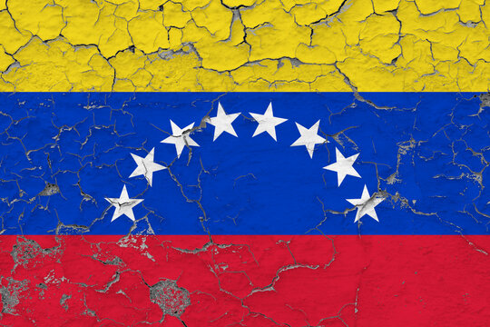 Venezuela flag close up grungy, damaged and weathered on wall peeling off paint to see inside surface. Vintage concept.
