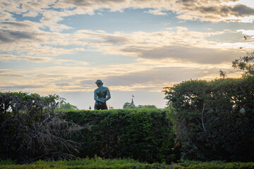 Paris, France - 06 14 2020: Statue of a man from the back, in the Louvre gardens at sunset