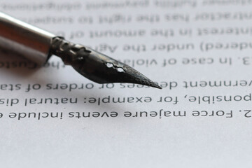 Fototapeta premium Definition of force majeure in a contract on a sheet of white office paper. Close-up macro photo, soft focus.