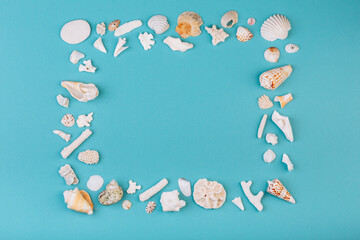 Frame for photo is made from different kinds of seashells, corals in front of a blue background, isolated with a caption for text. Vacation memory concept