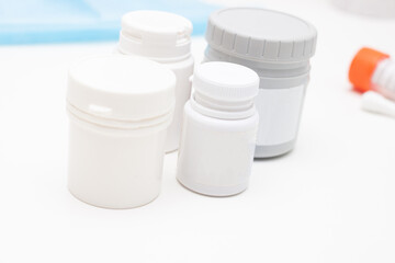 medical jars with pills on white table