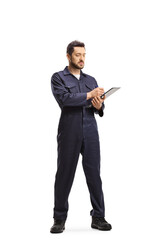 Auto mechanic in a uniform standing and writing a document