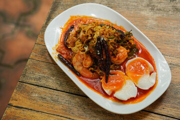 Winged betel nuts, fresh coconut milk and shrimp in a white plate on a wooden table background