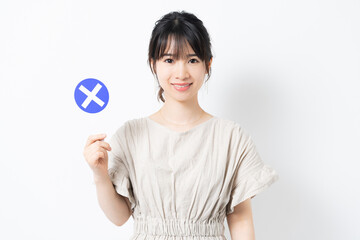 バツのプラカードを持つ若い女性