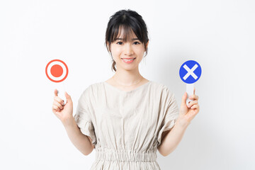 マルバツのプラカードを持つ若い女性