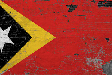 East Timor flag on grunge scratched concrete surface. National vintage background. Retro wall concept.