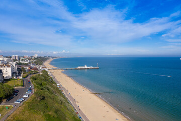 Aerial drone photo of the Bournemouth beach, Observation Wheel and Pier on a beautiful sunny summers day with lots of people relaxing and sunbathing on the British Dorset sandy beach and ocean