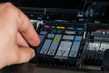 The man changes the ink for the printer