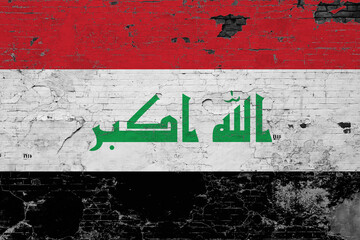 Obraz premium Iraq flag on grunge scratched concrete surface. National vintage background. Retro wall concept.