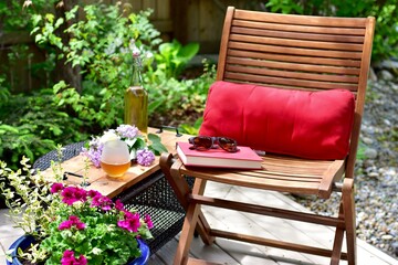 Outdoor patio seating in beautiful tranquil backyard sanctuary with beautiful landscaping for mindful relaxation on a warm summer afternoon during quarantine stay at home vacation