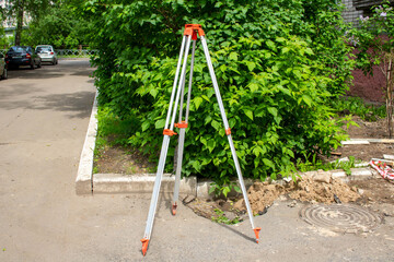 Fototapeta premium Surveyors equipment theodolite or total positioning station on the construction site of the road or building with construction machinery background