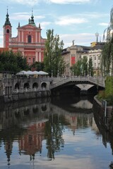 Fototapeta na wymiar Church and bridge over the river in Ljubljana