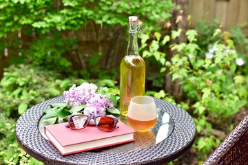 Outdoor relaxing patio in beautiful serene landscaped garden for sitting on a warm summer day with a glass of wine and book during a stay at home vacation during quarantine lockdown