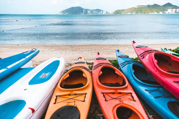 Coloured canoe boats on the seashore, outdoor activities at the resort in summer.