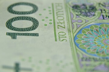 Polish currency banknote, paper money. Polish zloty (the masculine from the Polish word 'golden') closeup, selective focus. PLN 100 / 100 zl. Financial growth, home budget, saving money, business.