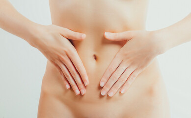 Naked young woman touches her belly