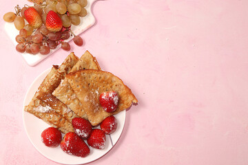 Pancakes with strawberries and chamomile tea on a light background. The concept of healthy and natural food. Healthy breakfast, food for children. selective focus., flat lay.