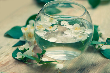 round glass vase with jasmine flowers float in the water. selective focus ,