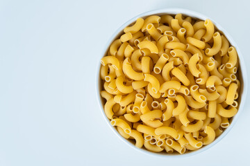 Raw dry uncooked Elbow Macaroni pasta spaghetti on white background. Good for basil tomato pesto sauce Homemade fresh Italian food organic whole wheat vegan spaghetti noodle for a healthy meal