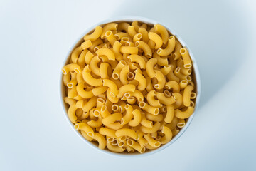 Raw dry uncooked Elbow Macaroni pasta spaghetti on white background. Good for basil tomato pesto sauce Homemade fresh Italian food organic whole wheat vegan spaghetti noodle for a healthy meal