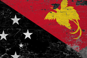 Papua New Guinea flag on grunge scratched concrete surface. National vintage background. Retro wall concept.