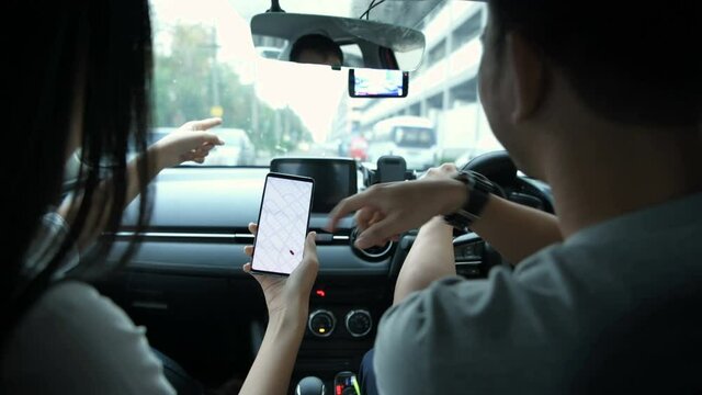 Navigation concept. Couple asian using smartphone with map in car. 4k Resolution.