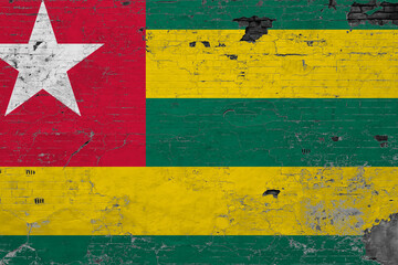 Togo flag on grunge scratched concrete surface. National vintage background. Retro wall concept.