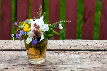 Close-up of a bouquet of wildflowers on a wooden background. selective focus, place for text